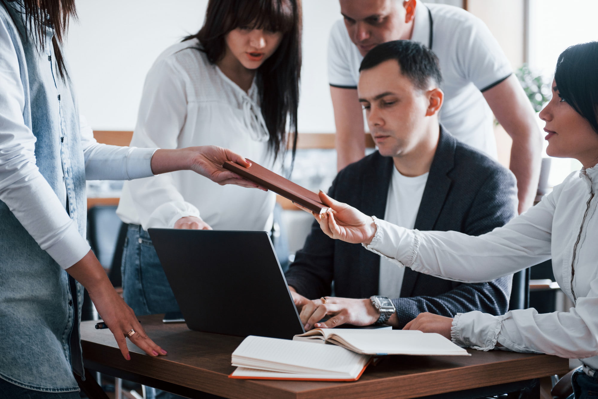 private-and-group-training-services-group-of-professionals-huddled-around-computer-for-training